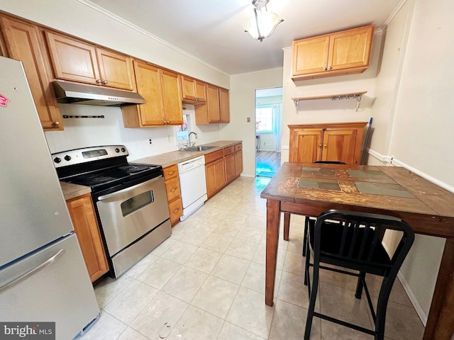 kitchen with ornamental molding, a sink, white appliances, under cabinet range hood, and baseboards