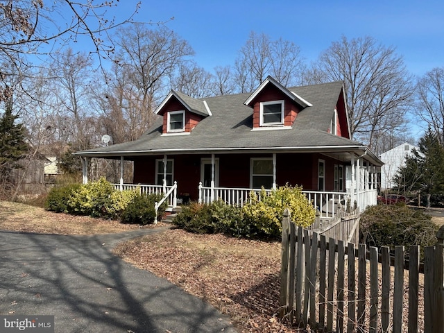 view of front facade featuring covered porch and fence