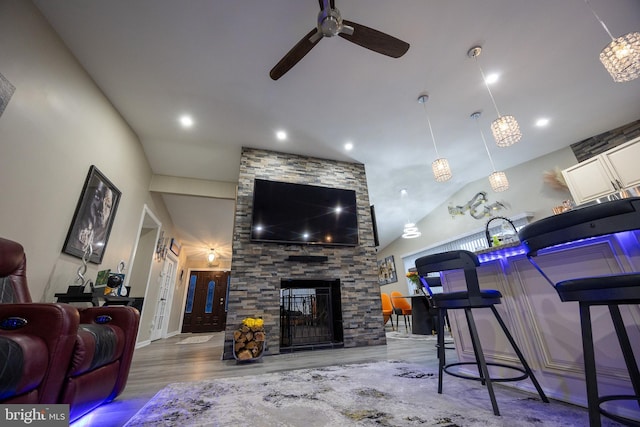 living room featuring recessed lighting, a ceiling fan, wood finished floors, and a stone fireplace