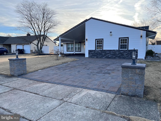 view of front of property featuring stone siding and decorative driveway