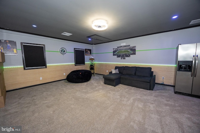 interior space featuring wooden walls, visible vents, wainscoting, ornamental molding, and carpet