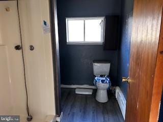 bathroom featuring baseboard heating, wood finished floors, and toilet