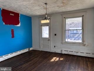 entryway with baseboard heating, wood finished floors, and a wealth of natural light