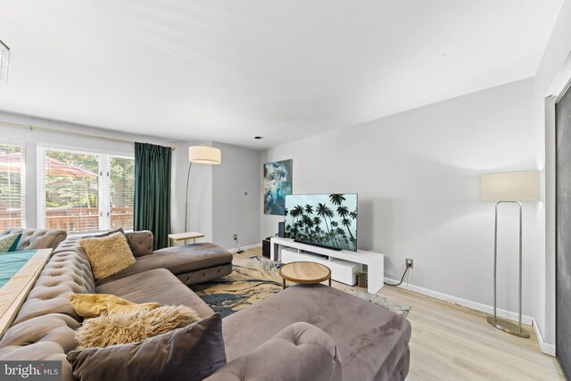 living area with baseboards and light wood-style flooring