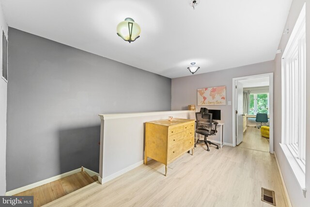 home office featuring visible vents, baseboards, and wood finished floors