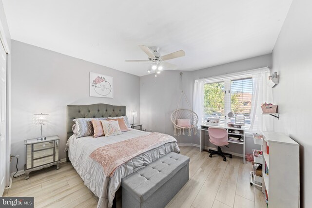 bedroom with light wood-type flooring, baseboards, and ceiling fan