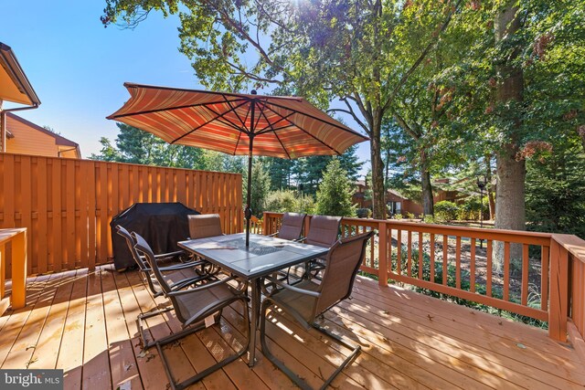 wooden terrace featuring area for grilling and outdoor dining area