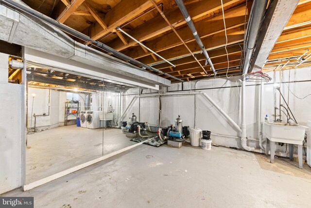 unfinished basement with independent washer and dryer and a sink