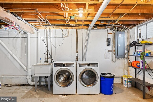 laundry room featuring a sink, laundry area, electric panel, and washer and clothes dryer