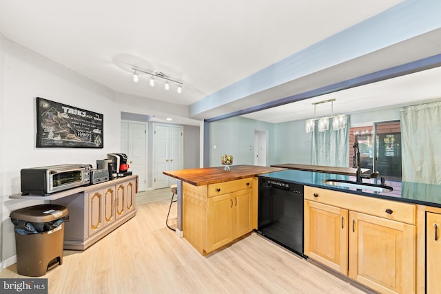 kitchen featuring light brown cabinets, light wood finished floors, a sink, black dishwasher, and pendant lighting