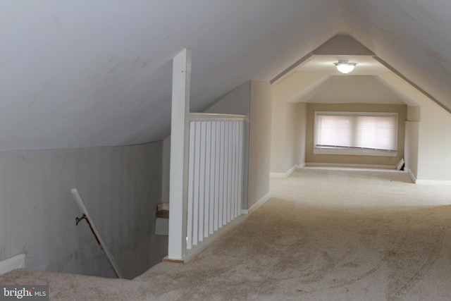 additional living space featuring vaulted ceiling and carpet flooring