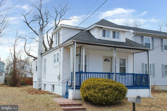 view of front facade with covered porch and roof with shingles