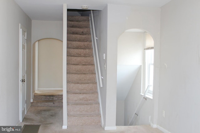 staircase with baseboards and visible vents