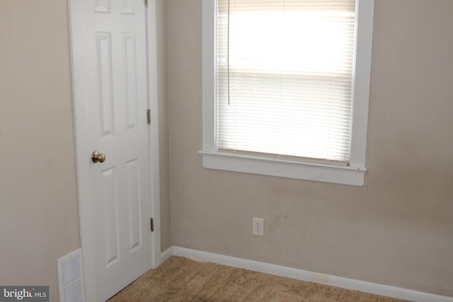 carpeted empty room with visible vents and baseboards