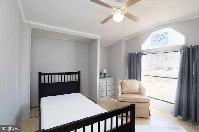 bedroom featuring light wood-style floors, ceiling fan, ornamental molding, and vaulted ceiling