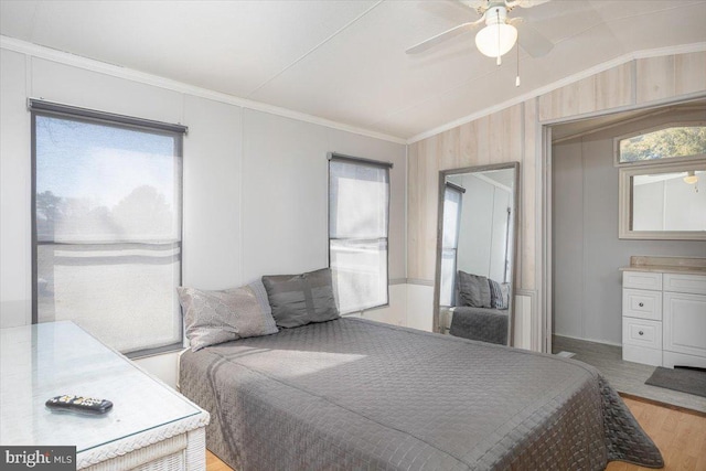 bedroom featuring lofted ceiling, multiple windows, wood finished floors, and crown molding