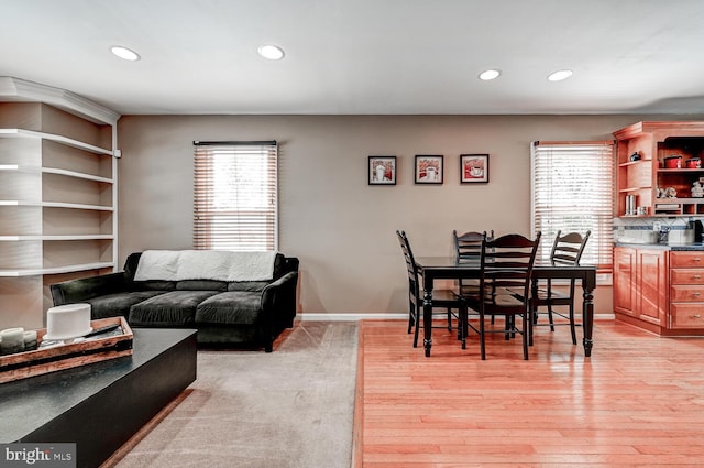 dining room featuring baseboards, light wood-type flooring, and recessed lighting