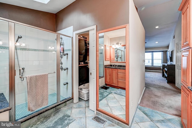 bathroom featuring a shower stall, vanity, and tile patterned floors