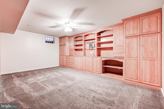 interior space with baseboards, a ceiling fan, and light colored carpet