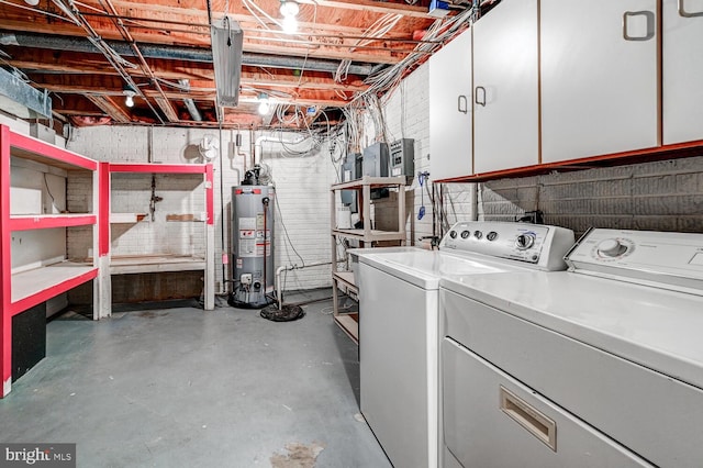 clothes washing area with laundry area, washer and clothes dryer, and gas water heater