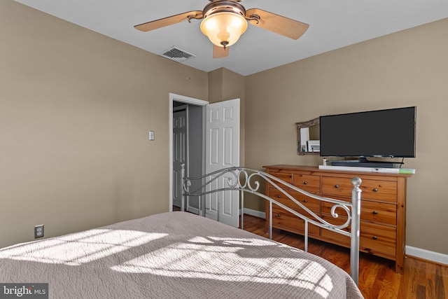 bedroom with a ceiling fan, wood finished floors, visible vents, and baseboards