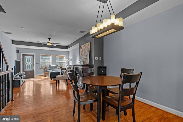 dining area featuring visible vents, baseboards, and wood finished floors