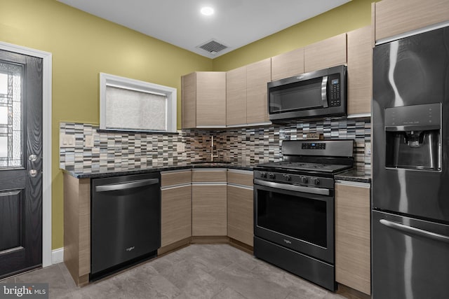 kitchen featuring stainless steel appliances, visible vents, backsplash, a sink, and modern cabinets