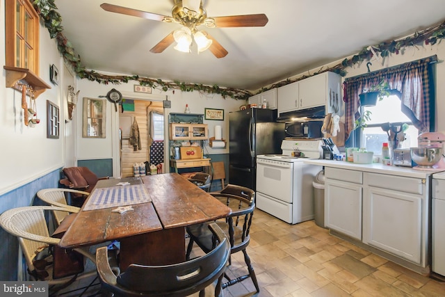 kitchen with white electric range oven, a ceiling fan, white cabinets, wainscoting, and under cabinet range hood