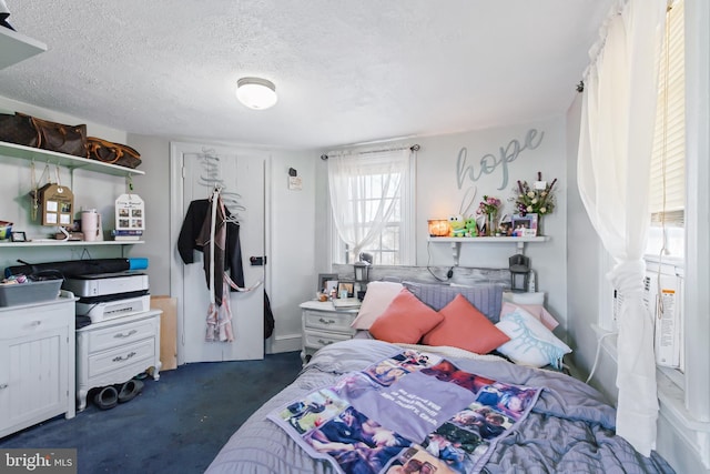 bedroom featuring dark colored carpet and a textured ceiling