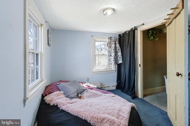 bedroom featuring carpet floors, baseboards, a baseboard heating unit, and a textured ceiling