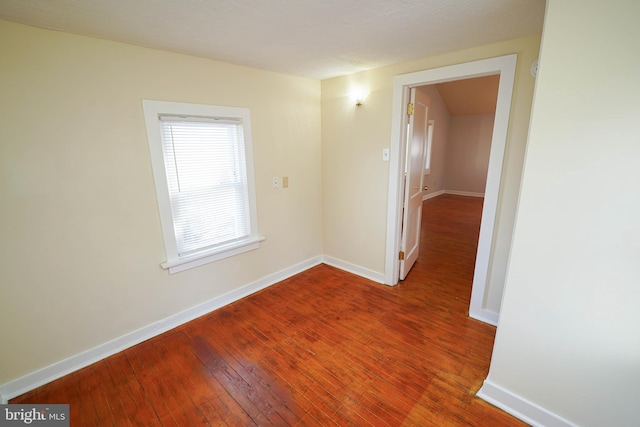 empty room with baseboards and hardwood / wood-style floors