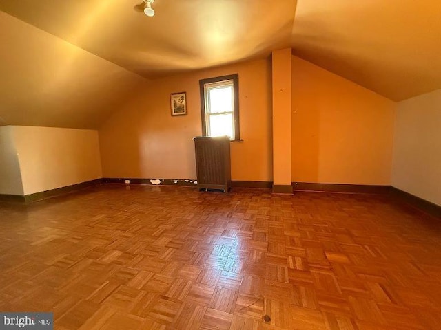 bonus room with vaulted ceiling and baseboards