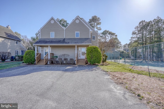 view of front of home featuring roof with shingles and fence