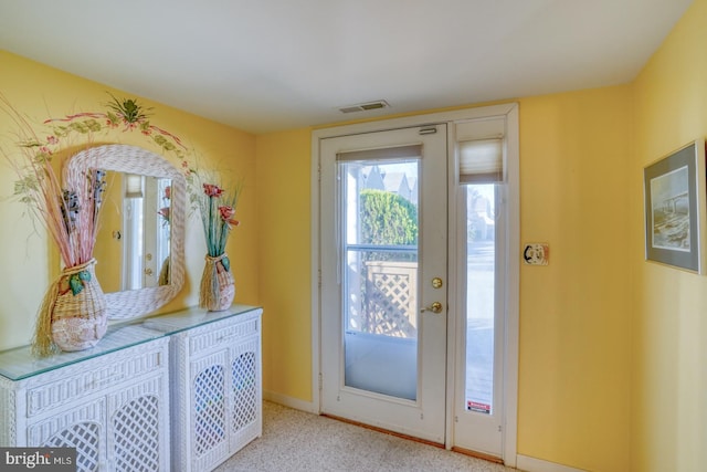 doorway to outside featuring visible vents, baseboards, and carpet floors