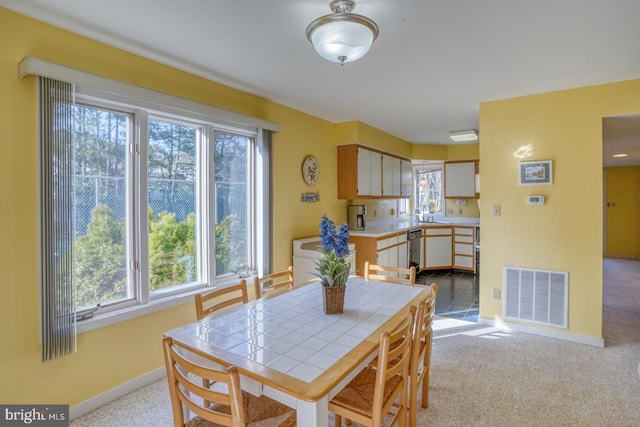 carpeted dining area with visible vents and baseboards