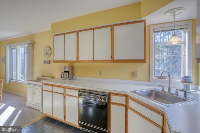 kitchen featuring a sink, decorative light fixtures, black dishwasher, carpet, and light countertops