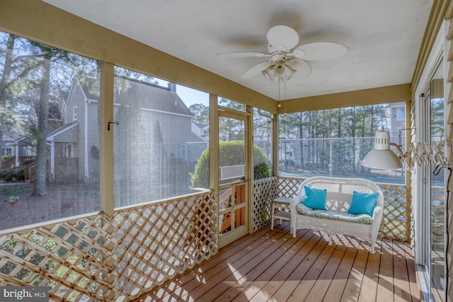 unfurnished sunroom featuring a ceiling fan