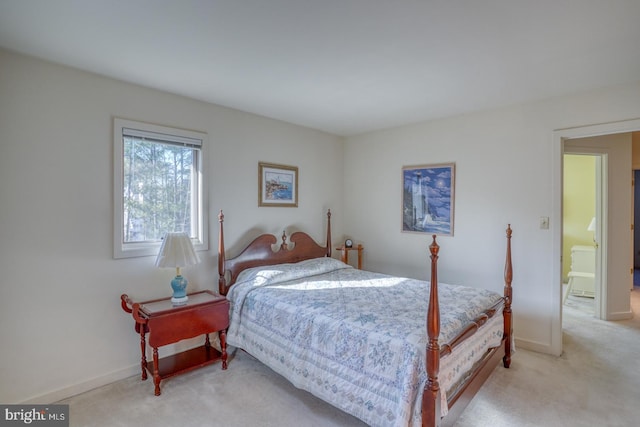 bedroom with light colored carpet and baseboards