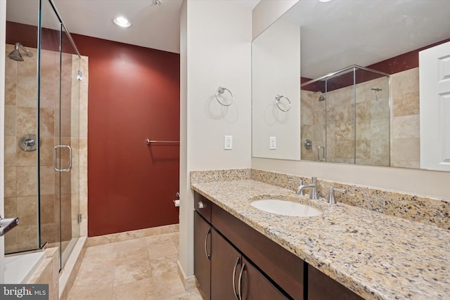 full bath featuring a stall shower, vanity, baseboards, and recessed lighting