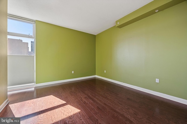 unfurnished room with baseboards and wood finished floors