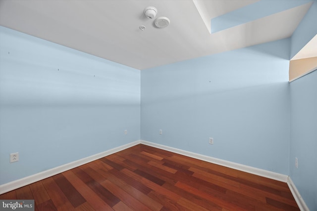 empty room with baseboards and wood finished floors