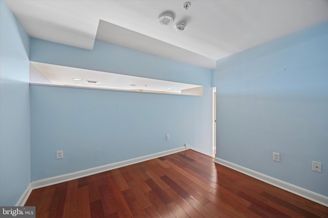 spare room featuring baseboards and hardwood / wood-style floors