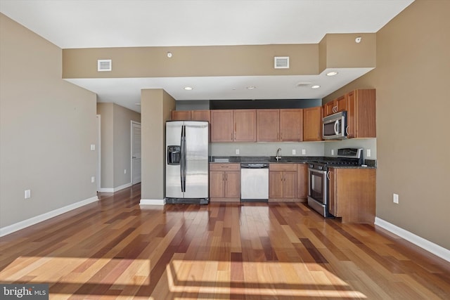 kitchen with dark countertops, visible vents, stainless steel appliances, and a sink