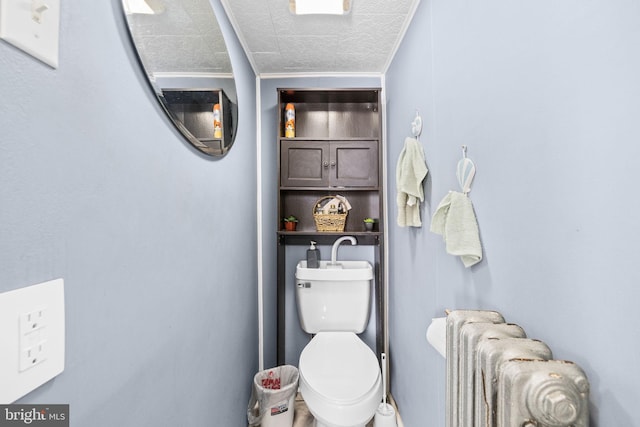 bathroom with toilet and radiator heating unit