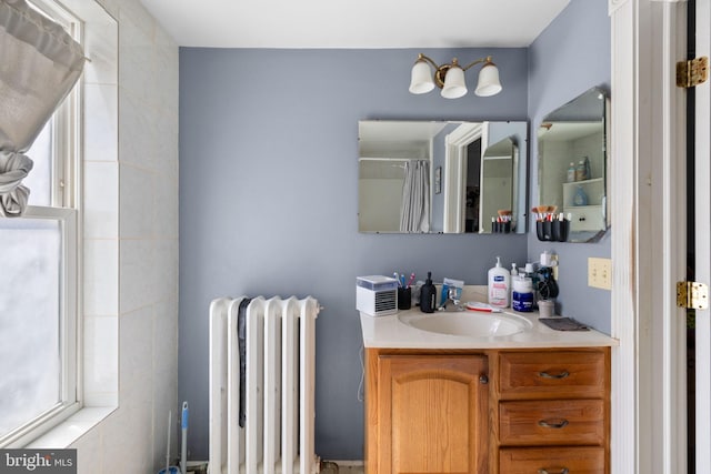 bathroom with curtained shower, vanity, and radiator heating unit