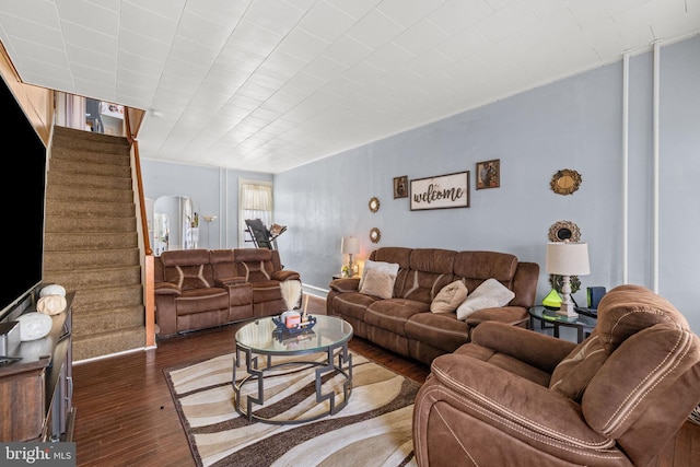 living area featuring wood finished floors, baseboards, and stairs