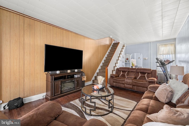 living room featuring arched walkways, wood finished floors, and stairs