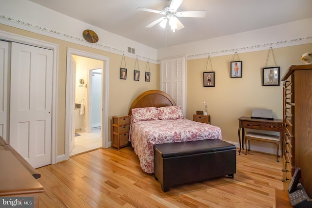 bedroom featuring baseboards, visible vents, light wood finished floors, and ensuite bathroom