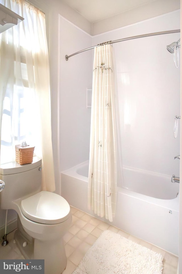 bathroom featuring a wealth of natural light, shower / bath combo, tile patterned flooring, and toilet