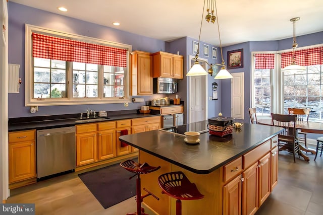 kitchen featuring stainless steel appliances, dark countertops, a sink, and recessed lighting